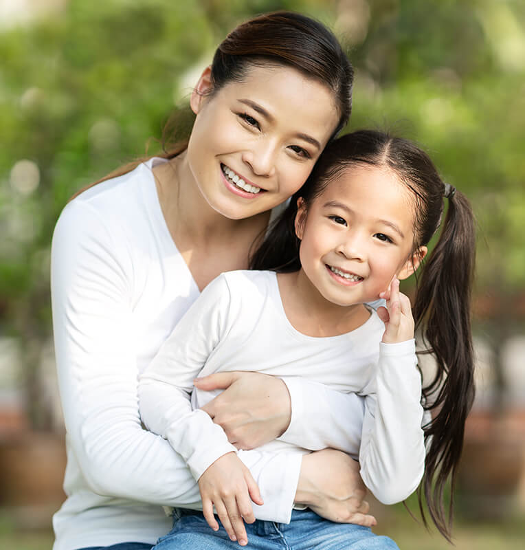 Mother and daughter smiling together in a supportive environment, emphasizing comfort and care for children with special needs during dental visits.