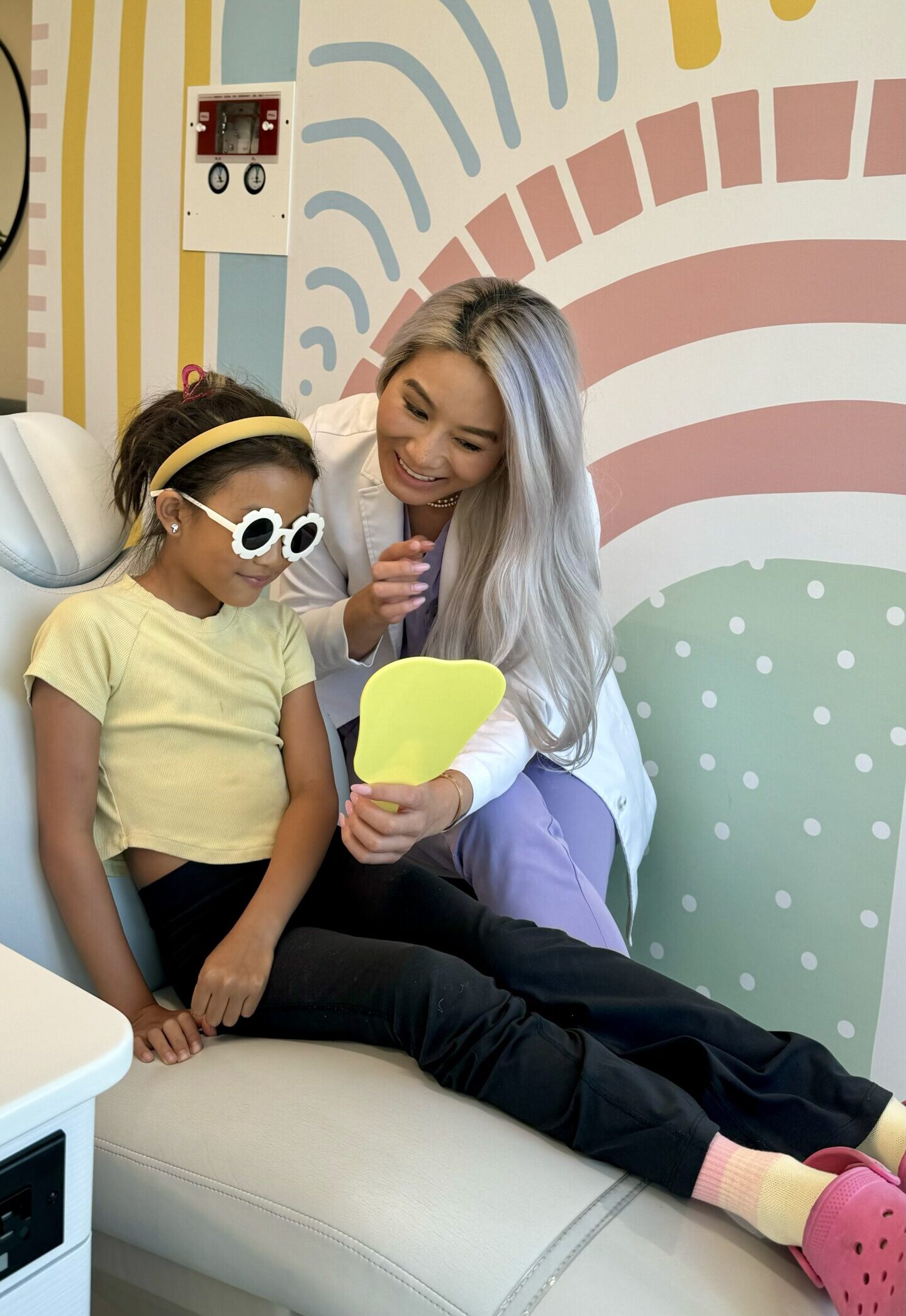 Child with sunglasses and mother during dental checkup at Kind Smiles Irvine.