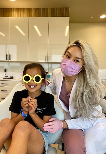 Young girl with fun sunglasses and dentist in a dental clinic.
