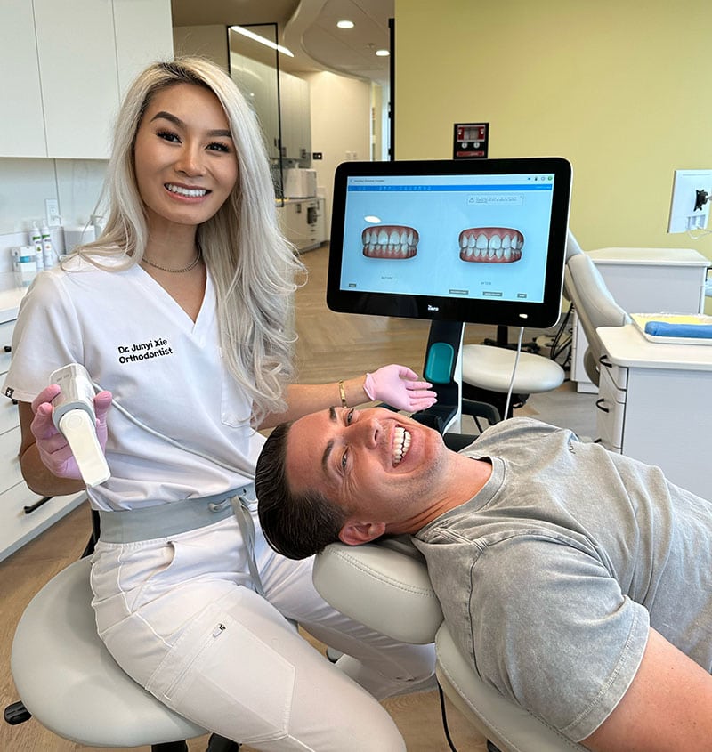 Orthodontist with patient in dental clinic for adult braces consultation.