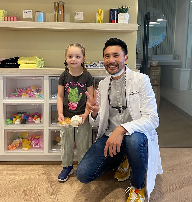 Pediatric dentist with a smiling girl in the office