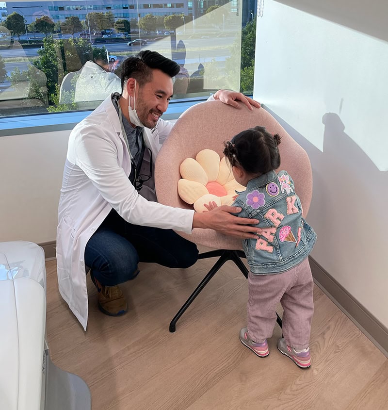 Pediatric dentist comforting child with sedation options at KIND SMILES in Irvine, CA.